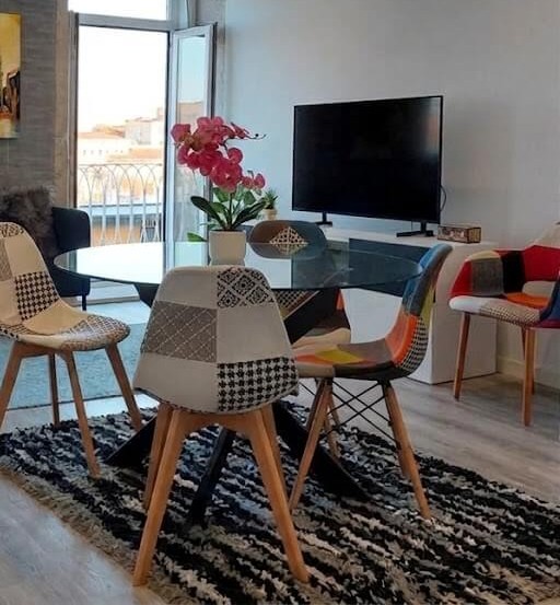 Living room with TV, tidy cabinet, green plant and yellow Clérigos Tower painting, Porto Skyline Center Residence