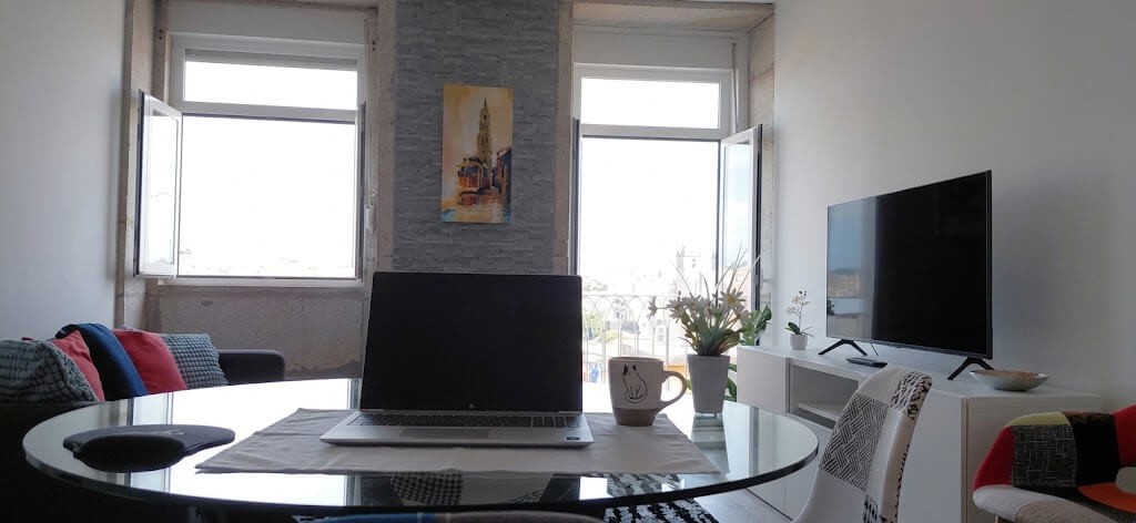 Living room with TV, Clérigos Tower painting and a city view from the dining table, Porto Skyline Center Residence