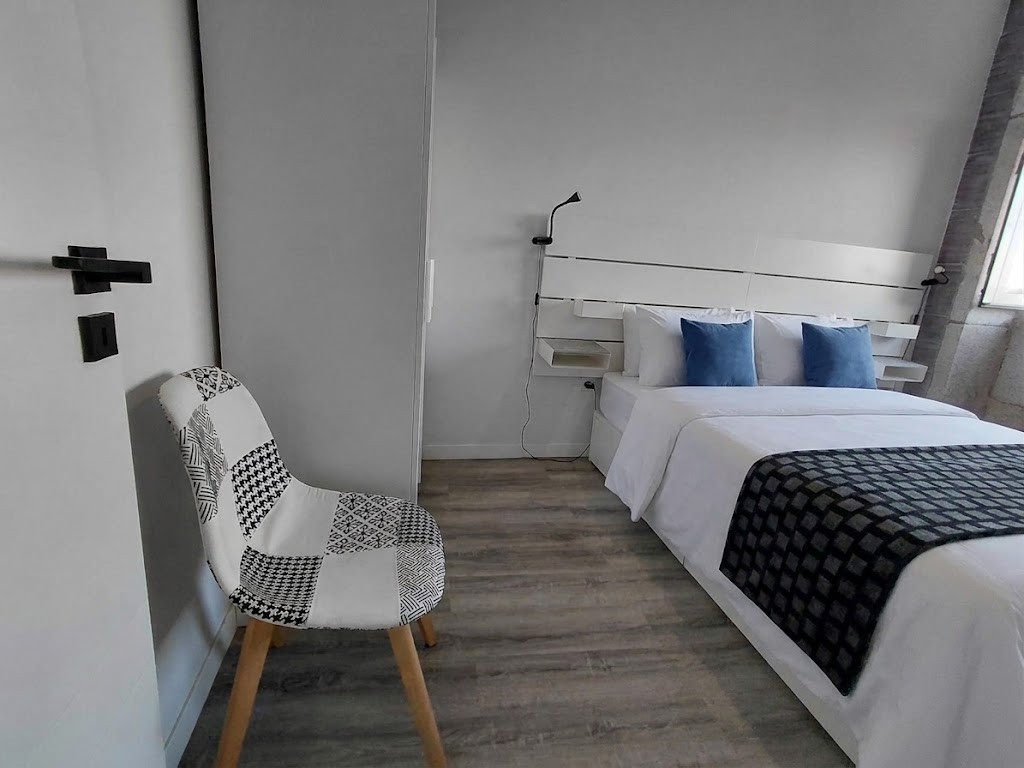 Main bedroom, reading corner with a patterned chair and white slatted headboard, Porto Skyline Center Residence